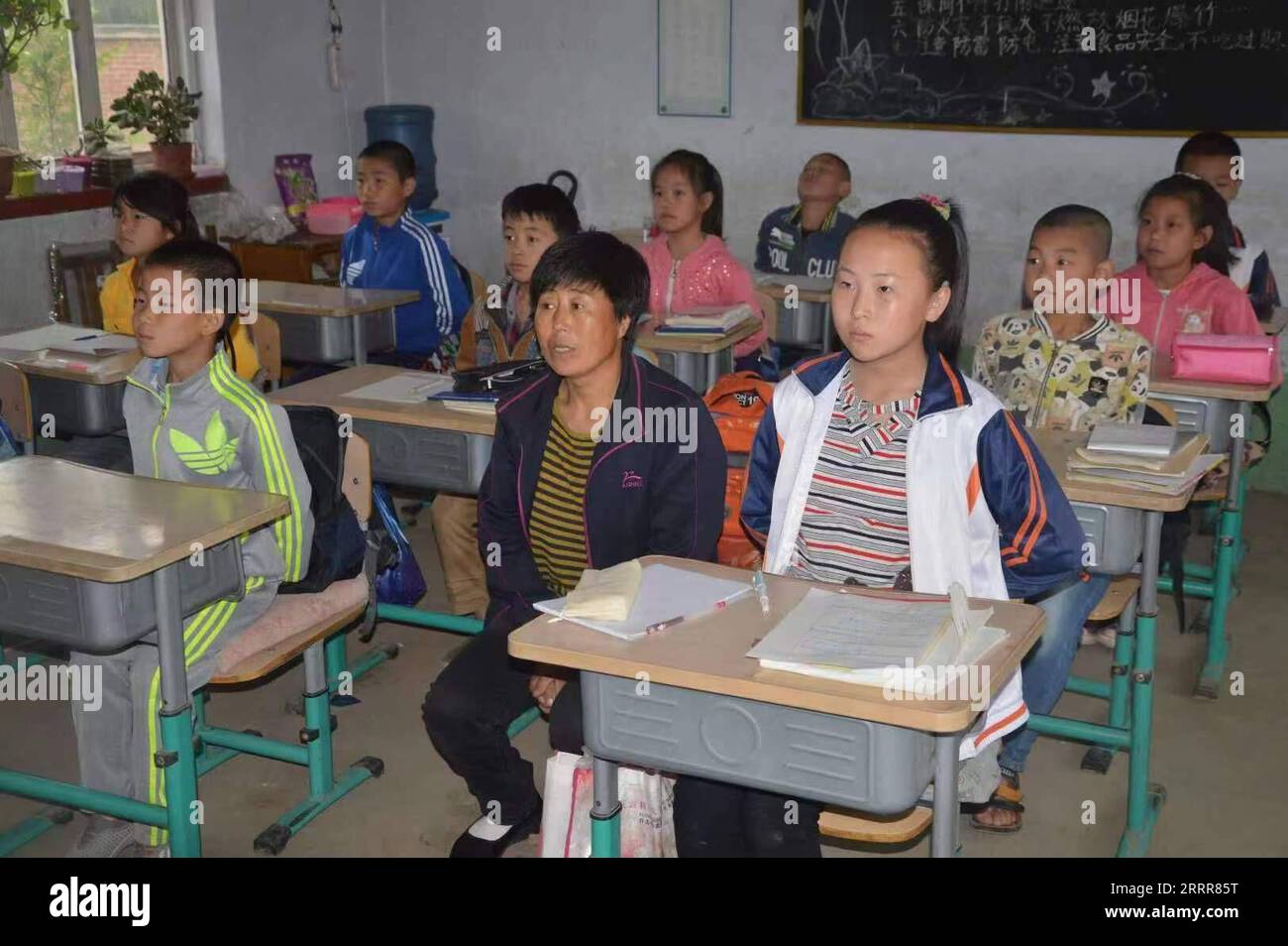 230513 -- HULUDAO, 13. Mai 2023 -- dieses undatierte Dateifoto zeigt Zhang Lianqin und Li Xinwei, die an einer Grundschule in der Stadt Xingcheng, Provinz Liaoning im Nordosten Chinas, teilnehmen. Zhang Lianqin, 55, Mutter von Li Xinwei, lebt im Dorf Liangjiatun, Gemeinde Hongyazi der Stadt Xingcheng. Da ihre Tochter Li an Hörstörungen leidet, begleitet Zhang Li seit Li in die Grundschule eingeschrieben wurde und kaum eine Klasse verpasst wurde, beim Studium in der Schule. Zhang saß in der Nähe ihrer Tochter, um als Lis Ohren im Klassenzimmer zu fungieren. Das Leben von Zhang und ihrer Familie ist nicht gut. Sie leben mich Stockfoto