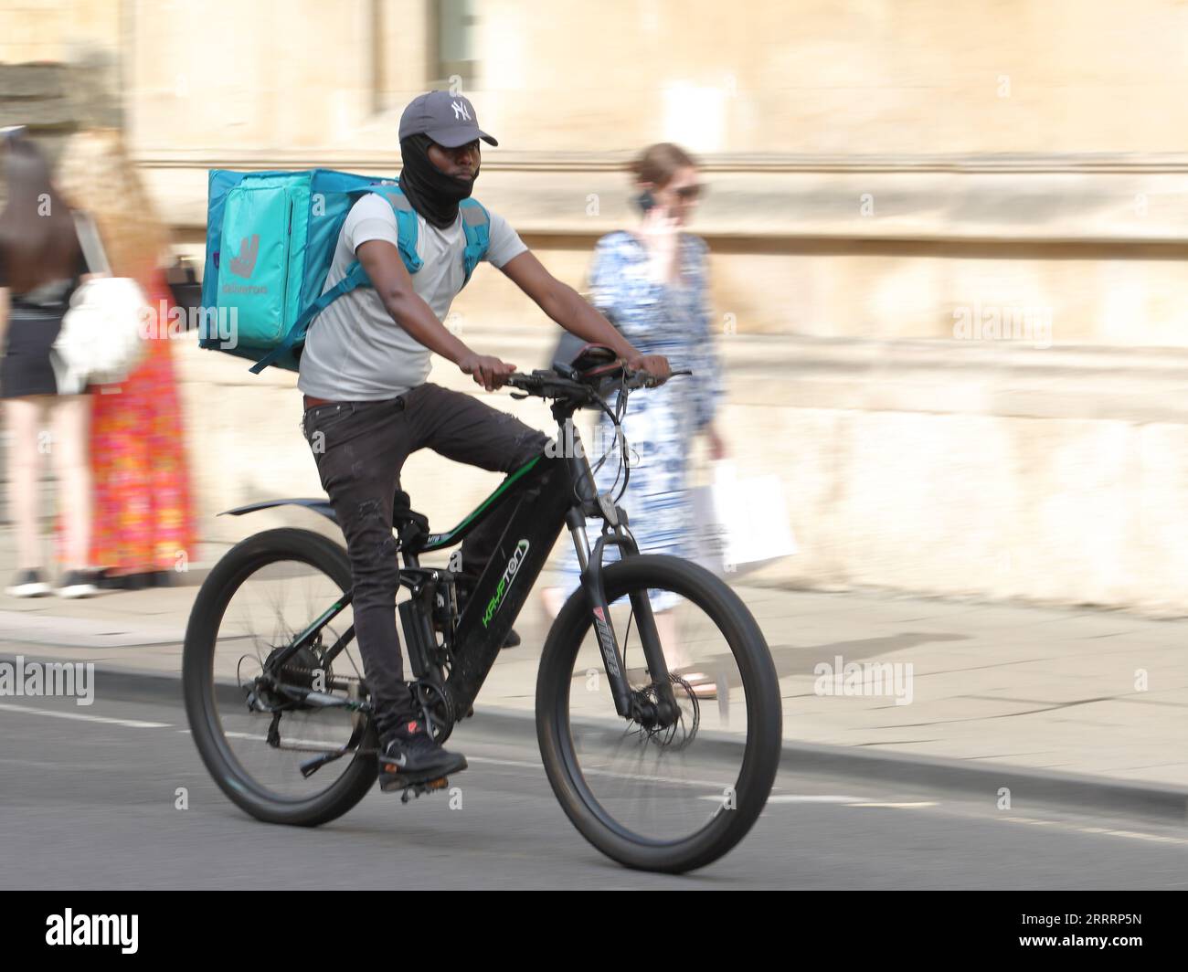 Männlicher Deliveroo-Fahrer auf einem Fahrrad in Oxford, Großbritannien Stockfoto