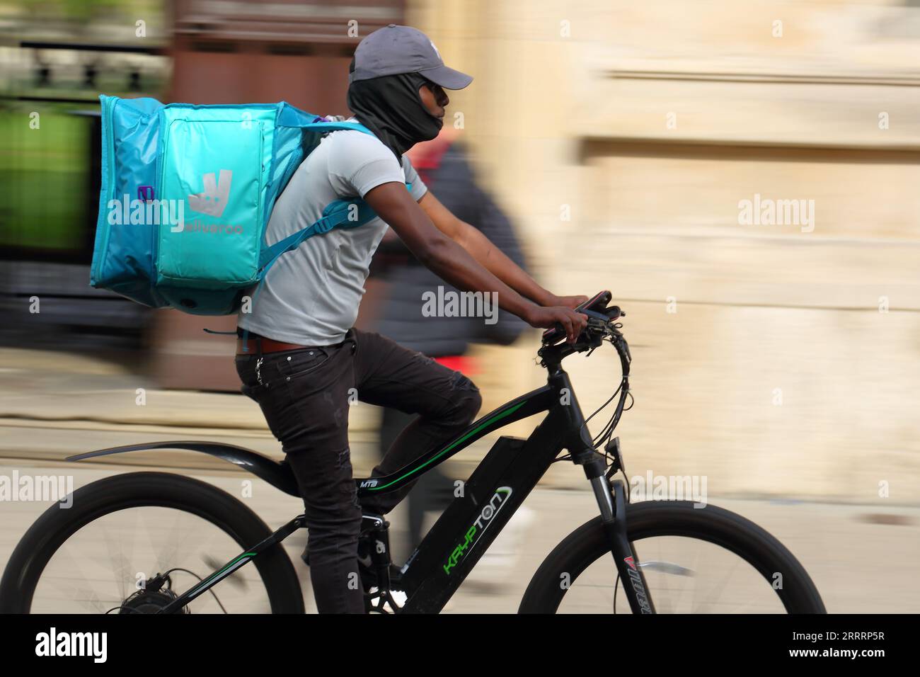 Männlicher Deliveroo-Fahrer auf einem Fahrrad in Oxford, Großbritannien Stockfoto