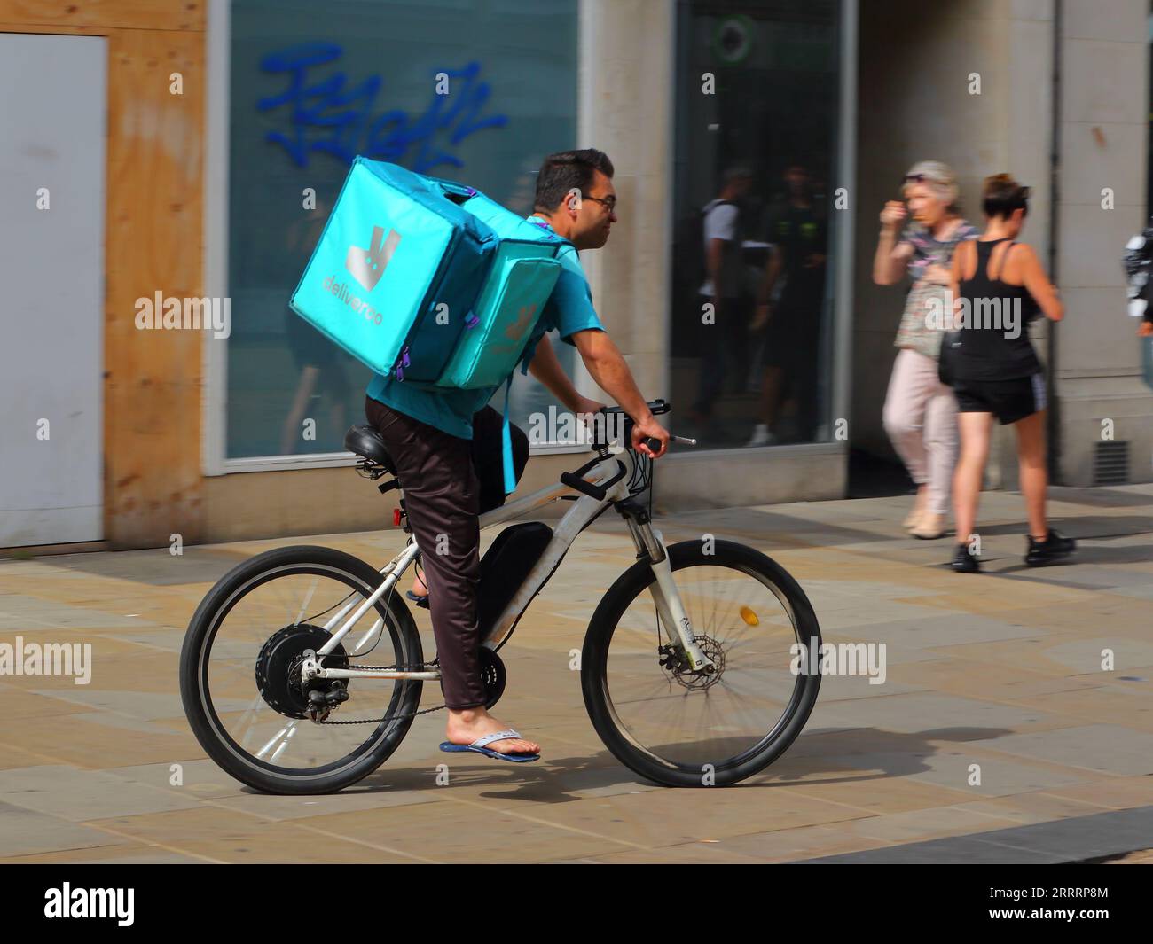 Männlicher Deliveroo-Fahrer auf einem Fahrrad in Oxford, Großbritannien Stockfoto