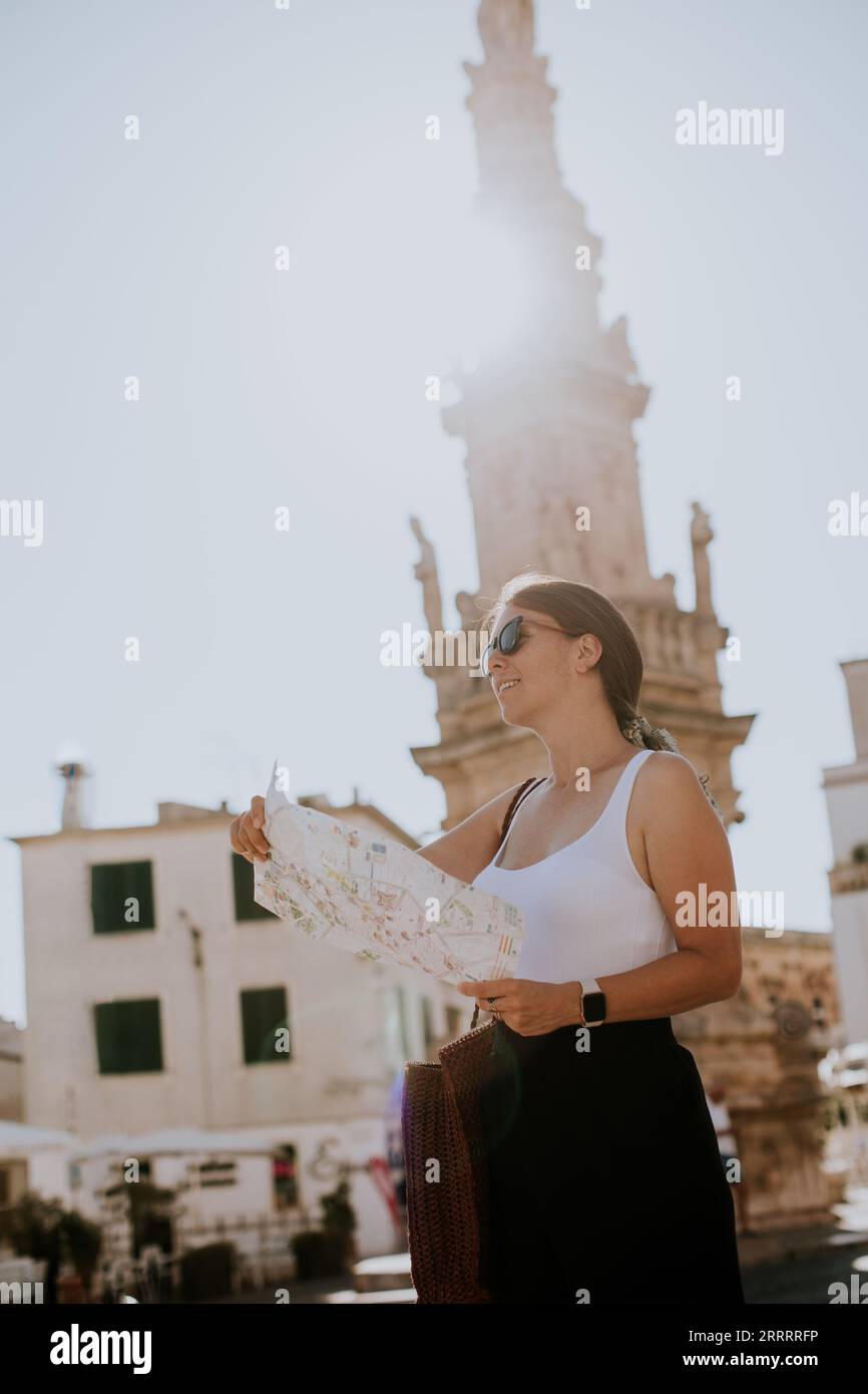 Weibliche Touristen mit einem Stadtplan von der Statue des Heiligen Oronzo in Ostuni, Italien Stockfoto