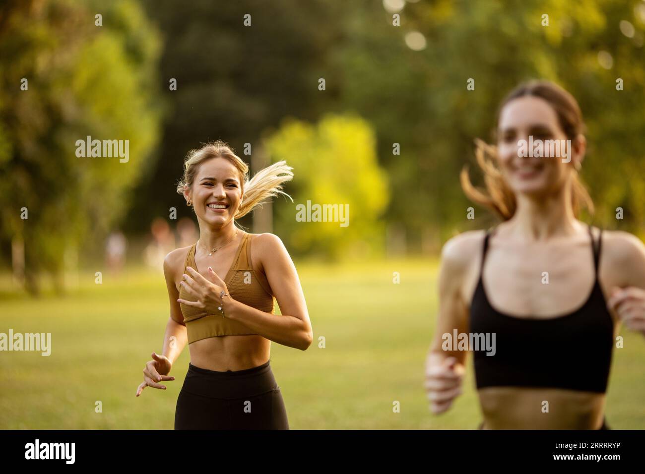 Zwei hübsche junge Frauen Rennen im Park Stockfoto