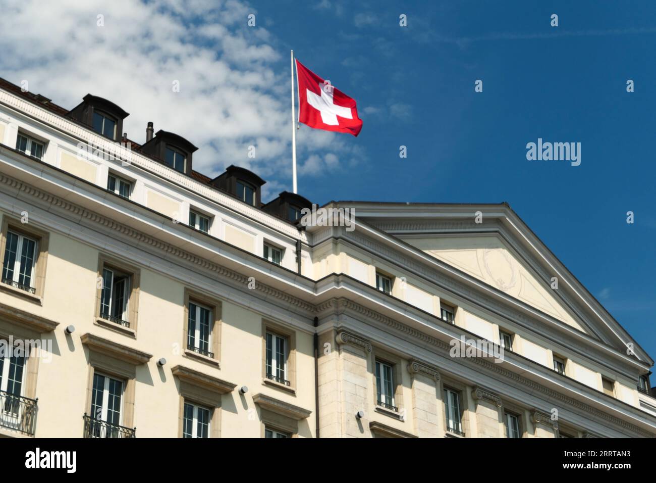 Genf, schweiz. August. 2023. Die im Wind flatternde Schweizer Nationalflagge auf einem Gebäude im Genfer Seengebiet. Stockfoto