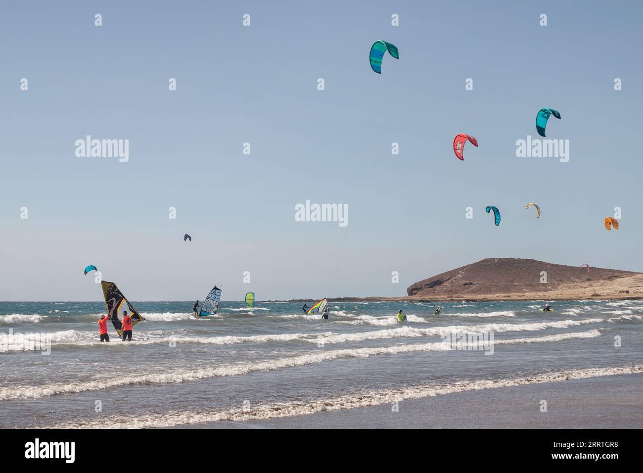Menschen, die Wassersport an einem perfekten windigen Tag ausüben, beliebtes Touristenziel mit privilegierten Wetterbedingungen das ganze Jahr über in El Medano Stockfoto