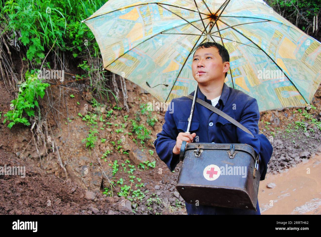 230726 -- GUIYANG, 26. Juli 2023 -- dieses Foto vom 4. Juli 2012 zeigt Zhu Daqing auf einer matschigen Straße auf dem Weg zu einem Patienten im Dorf Xinshui, Mazha Stadt im autonomen Bezirk Yi-Hui-Miao von Weining, Provinz Guizhou im Südwesten Chinas. Zhu Daqing ist ein Landarzt im Dorf Xinshui, Mazha, im autonomen County Yi-Hui-Miao von Weining. Zhu Daqing wurde in einer Familie mit Generationen von Ärzten geboren und war in jungen Jahren entschlossen, Arzt wie sein Vater zu werden, obwohl er aufgrund angeborener Abwesenheit der oberen Extremität im linken Unterarm behindert ist. Studium der traditionellen chinesischen Medizin, ZH Stockfoto