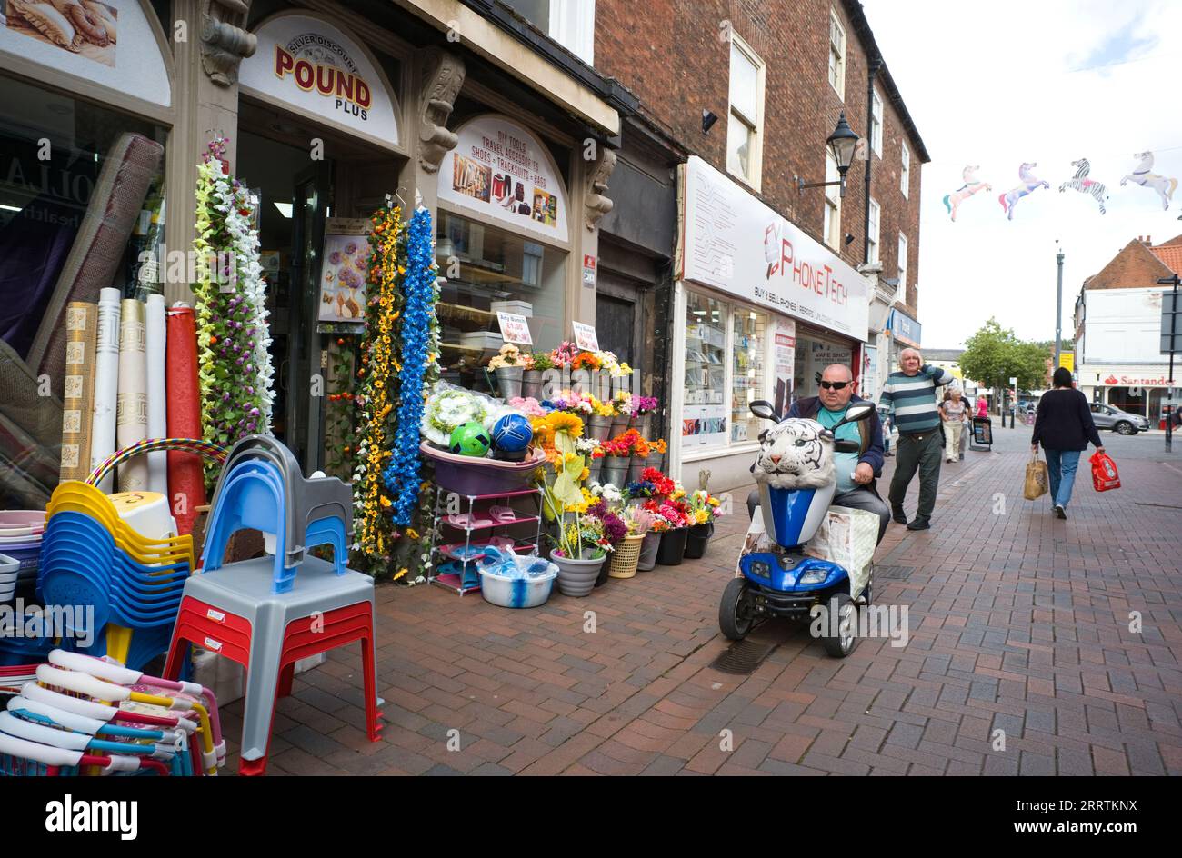 Mann auf Mobilitätsroller mit Schneeleopardenkopf vorne Stockfoto