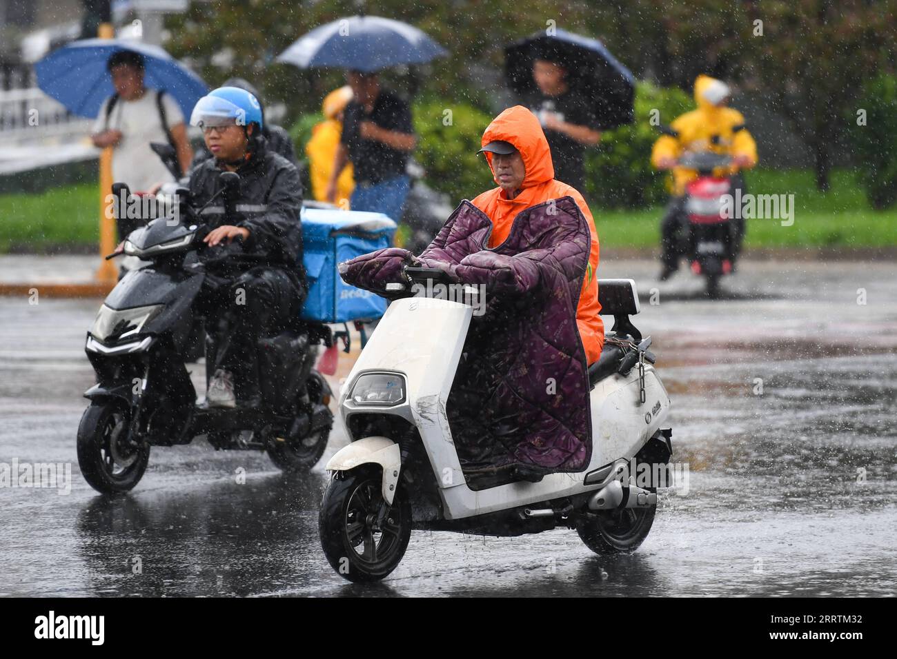 230730 -- PEKING, 30. Juli 2023 -- Menschen fahren mit Motorrollern im Regen in Peking, Hauptstadt von China, 30. Juli 2023. Vom Taifun Doksuri, dem fünften Taifun dieses Jahres, betroffen, haben starke Niederschläge nordchinesische Regionen getroffen, darunter Peking, Hebei und Shandong. CHINA-BEIJING-RAININSTORM CN JuxHuanzong PUBLICATIONxNOTxINxCHN Stockfoto