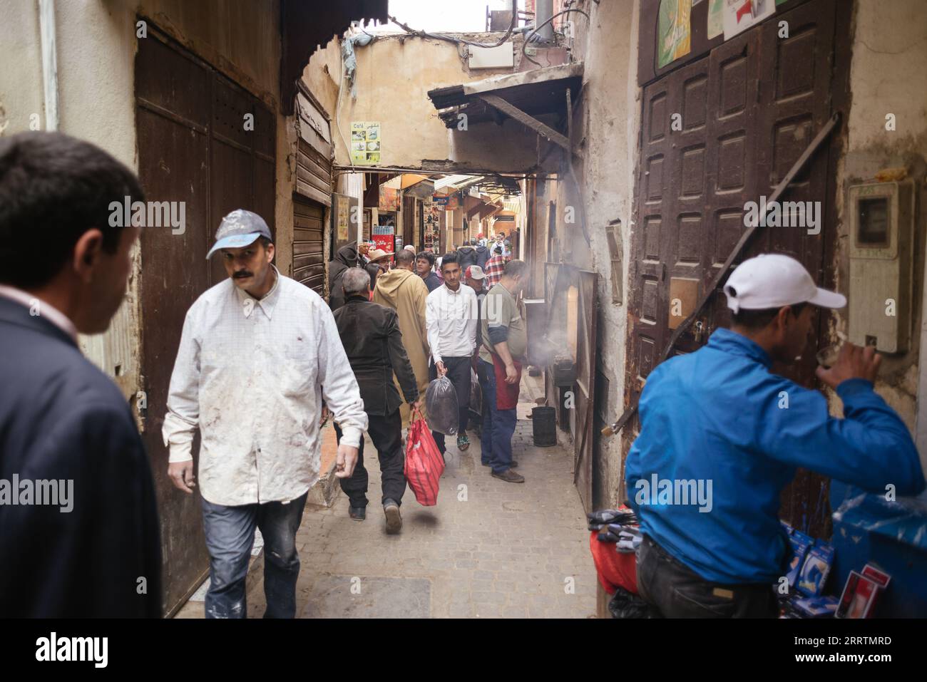Marrakesch, Marokko-6. November 2019: Marokkanische Stadtlandschaft. Menschen, die durch die engen Gassen alter Gebäude gehen. Stockfoto