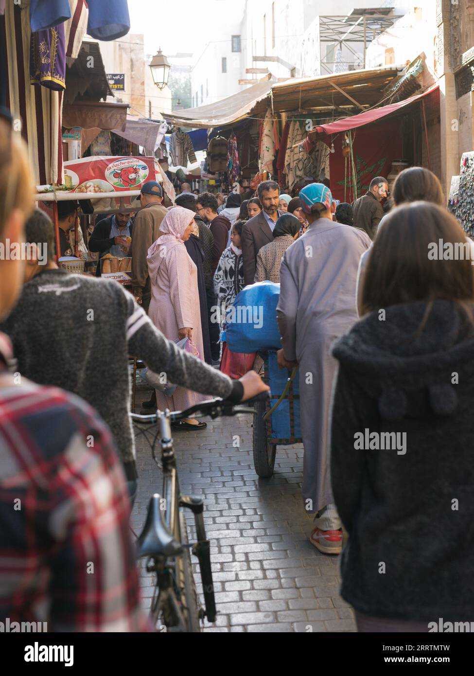 Marrakesch, Marokko-6. November 2019: Marokkanische Stadtlandschaft. Menschen, die durch die engen Gassen alter Gebäude gehen. Stockfoto
