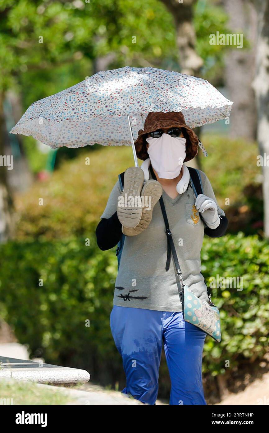 230803 -- BUSAN, 3. August 2023 -- Eine Frau geht an einem heißen Sommertag in Busan, Südkorea, 3. August 2023 auf der Straße. SÜDKOREA-BUSAN-HITZEWELLE WangxYiliang PUBLICATIONxNOTxINxCHN Stockfoto