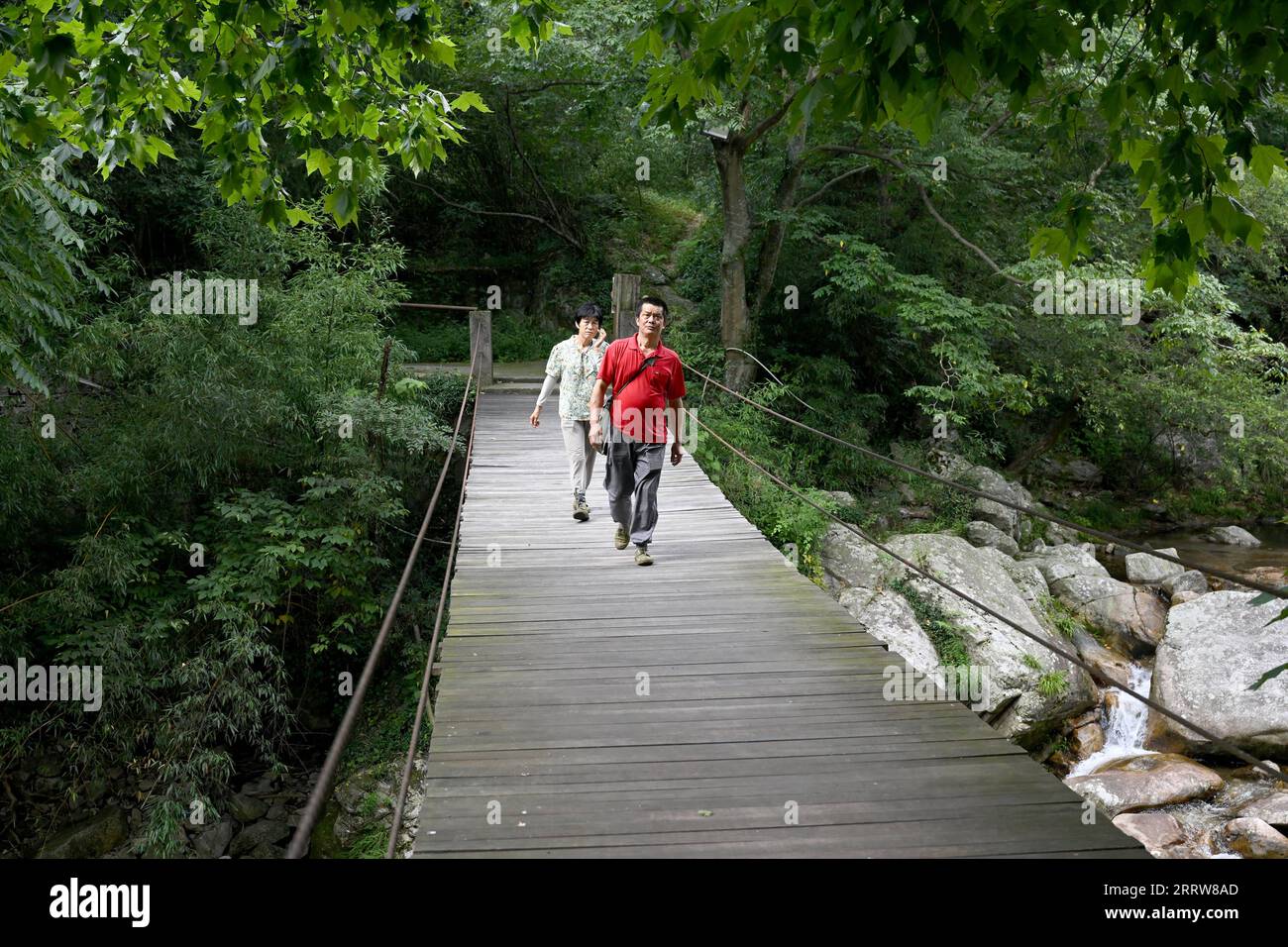 230814 -- LU AN, 14. August 2023 -- Wang Kedong und seine Frau Gao Kaiyu patrouillieren auf der Tiantangzhai Management Station im Anhui Tianma National Nature Reserve, ostchinesische Provinz Anhui, 12. August 2023. Wang Kedong und Gao Kaiyu, beide 58 Jahre alt, sind Ranger der Tiantangzhai Management Station des Anhui Tianma National Nature Reserve. Sie leben das ganze Jahr über in den Bergen und patrouillieren seit 25 Jahren täglich auf einer Strecke von mehr als 20 Kilometern. Das Anhui Tianma National Nature Reserve wurde 1998 auf der Grundlage von zwei ehemaligen Anhui Provincial Nature Reserves gegründet. Sie befindet sich an der tr Stockfoto