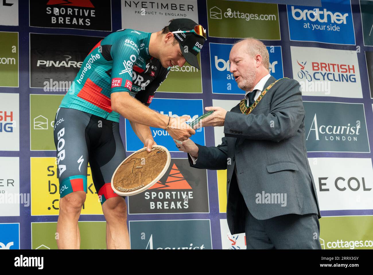 Sieger Danny van Poppel feiert beim Tour of Britain-Radrennen Stage 6 am Ziel in Harlow, Essex, Großbritannien. Ratsmitglied Andrew Johnson präsentiert Stockfoto