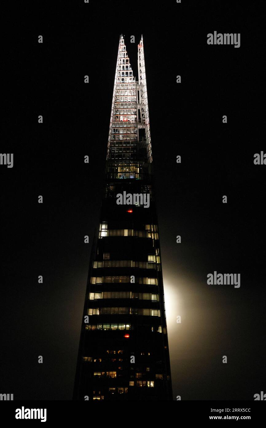 Die Shard in der Nacht mit dem Schein eines Vollmonds hinter dem Gebäude. Stockfoto