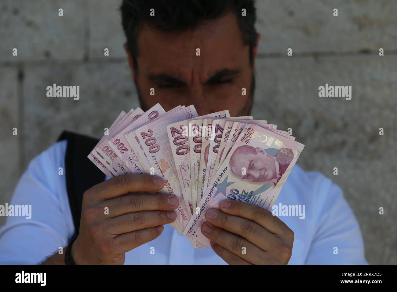 230824 -- ANKARA, 24. Aug. 2023 -- Ein Mann zählt türkische Lira in einer Wechselstube in Ankara, T¹rkiye, am 24. Aug. 2023. Die Zentralbank von T¹rkiye hat am Donnerstag ihren Referenzzinssatz um 750 Basispunkte auf 25 Prozent angehoben, und zwar von 17,5 Prozent, als Gegengewicht zu hoher Inflation und Wechselkursschwankungen. /Handout über Xinhua TRKIYE-ANKARA-BENCHMARK-ZINSANHEBUNG MustafaxKaya PUBLICATIONxNOTxINxCHN Stockfoto