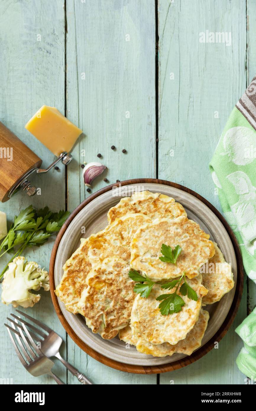 Gebratene vegetarische Schnitzel oder Pfannkuchen. Blumenkohl-Gemüsebrühe mit Käse auf einem rustikalen Küchentisch. Ansicht von oben. Leerzeichen kopieren. Stockfoto