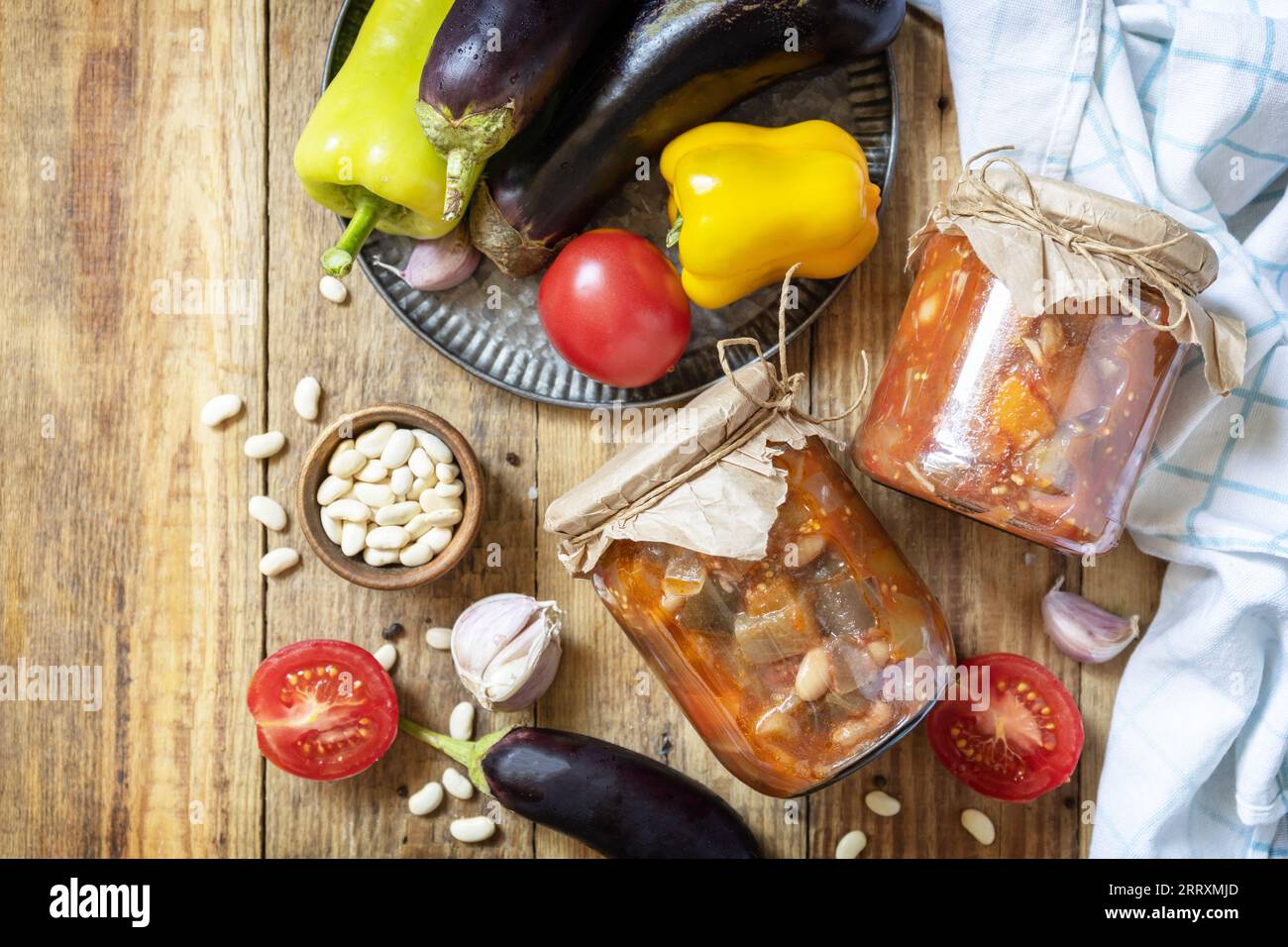 Gesundes, hausgemachtes fermentiertes Essen. Salat Aubergine mit Beanson ein rustikaler Tisch. Hauswirtschaft, Herbsternteerhaltung. Ansicht von oben. Stockfoto