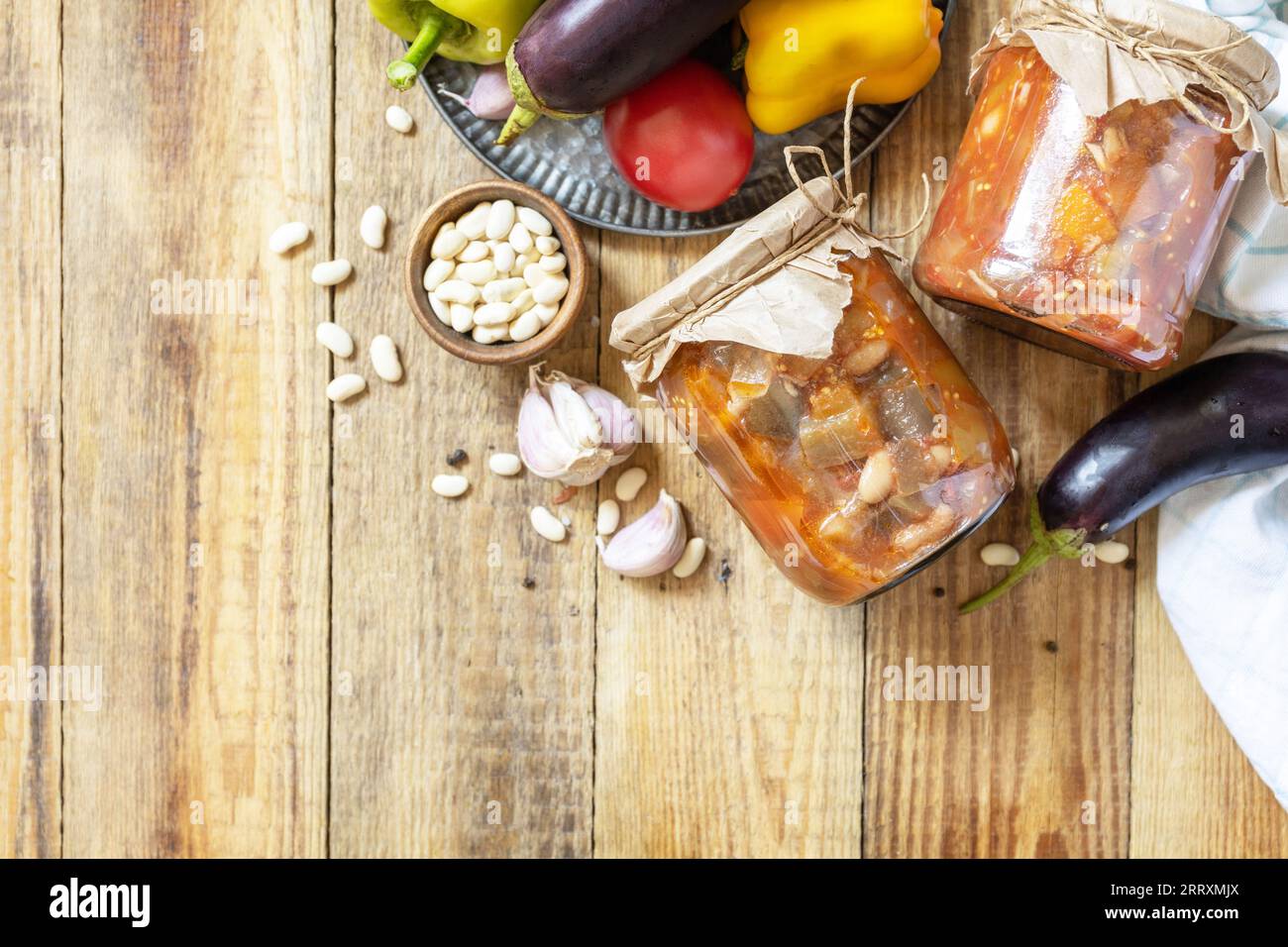 Gesundes, hausgemachtes fermentiertes Essen. Salat Aubergine mit Beanson ein rustikaler Tisch. Hauswirtschaft, Herbsternteerhaltung. Ansicht von oben. Leerzeichen kopieren. Stockfoto
