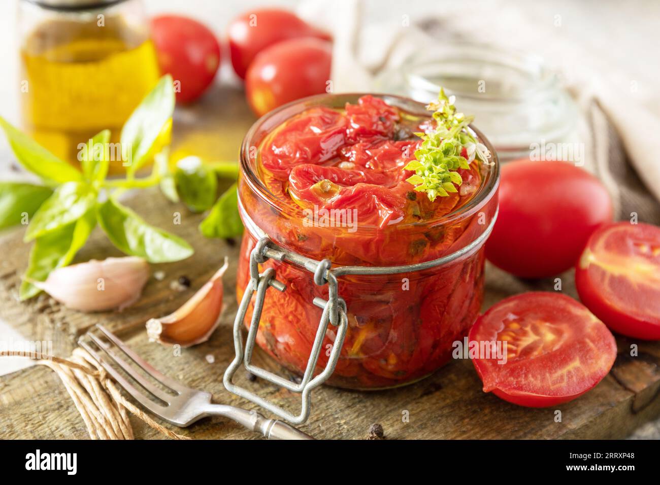 Sonnengetrocknete Tomaten im Glas mit Gewürzen und Kräutern. Gesundes, hausgemachtes fermentiertes Essen. Hauswirtschaft, Herbsternteerhaltung. Stockfoto