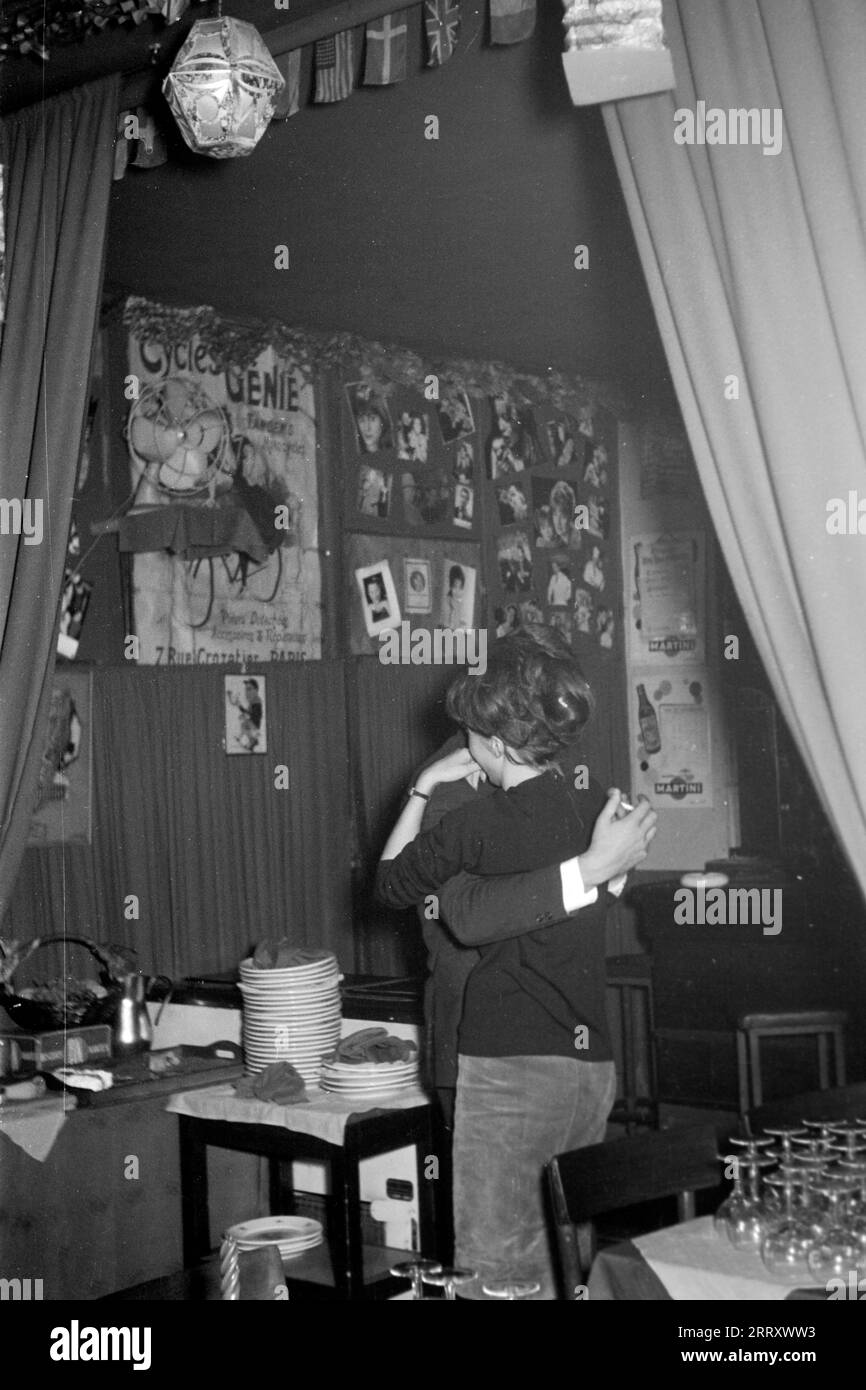 Ein paar tanzt eng umschlungen in einem Pariser Lokal, 1962. Ein Paar tanzt in einer Pariser Bar, 1962. Stockfoto