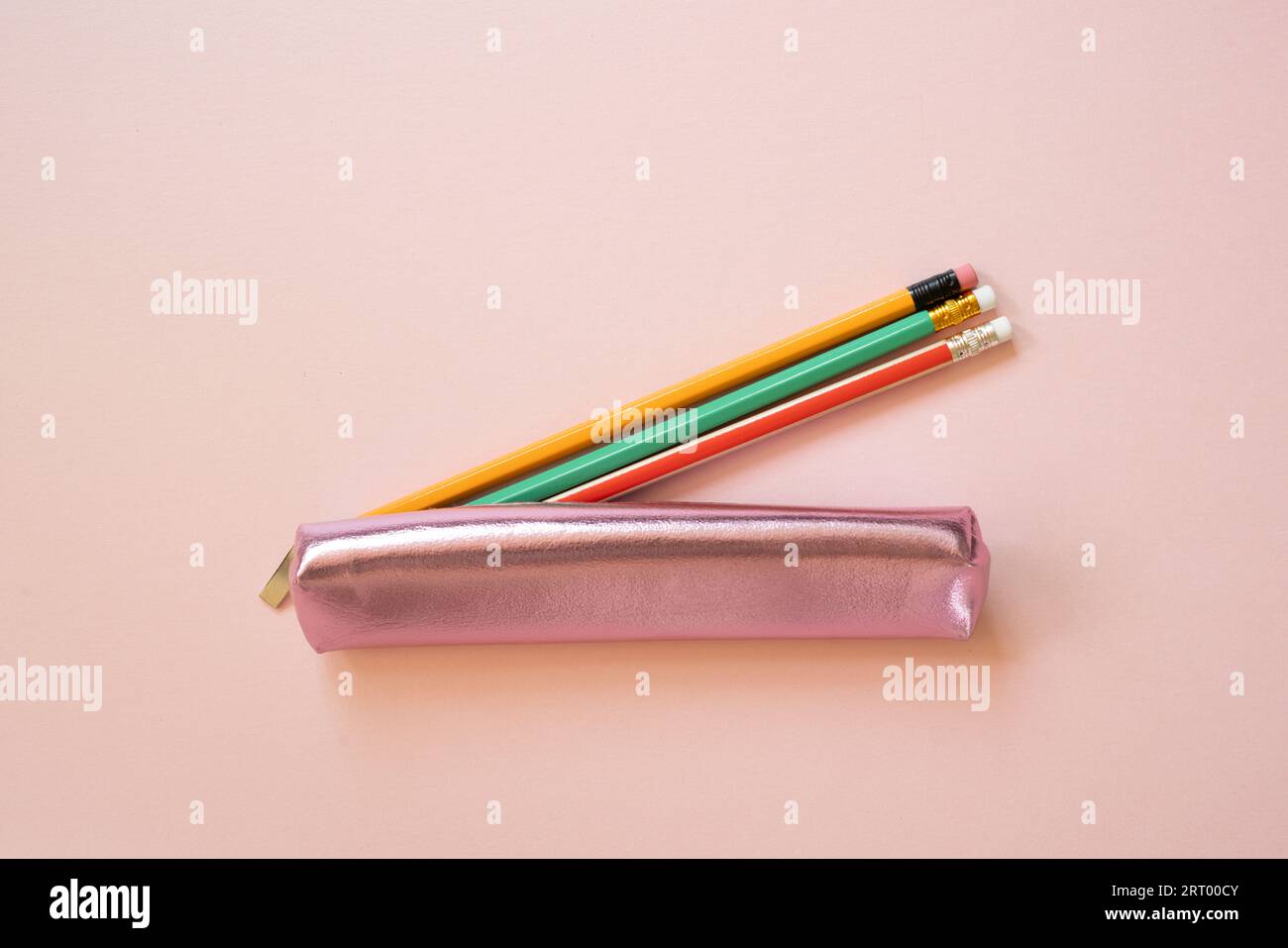 Pinkfarbener Stiftemäppchen mit isoliertem Schreibmaterial auf rosafarbenem Hintergrund. Draufsicht Stockfoto