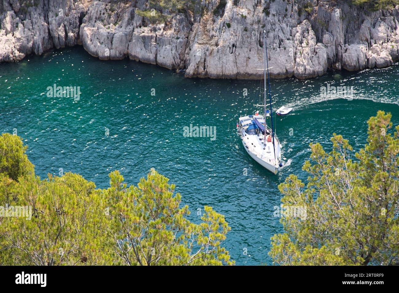Ein malerischer Blick auf Ein Boot, das in den türkisfarbenen Gewässern von Cassis, Frankreich, segelt. Stockfoto