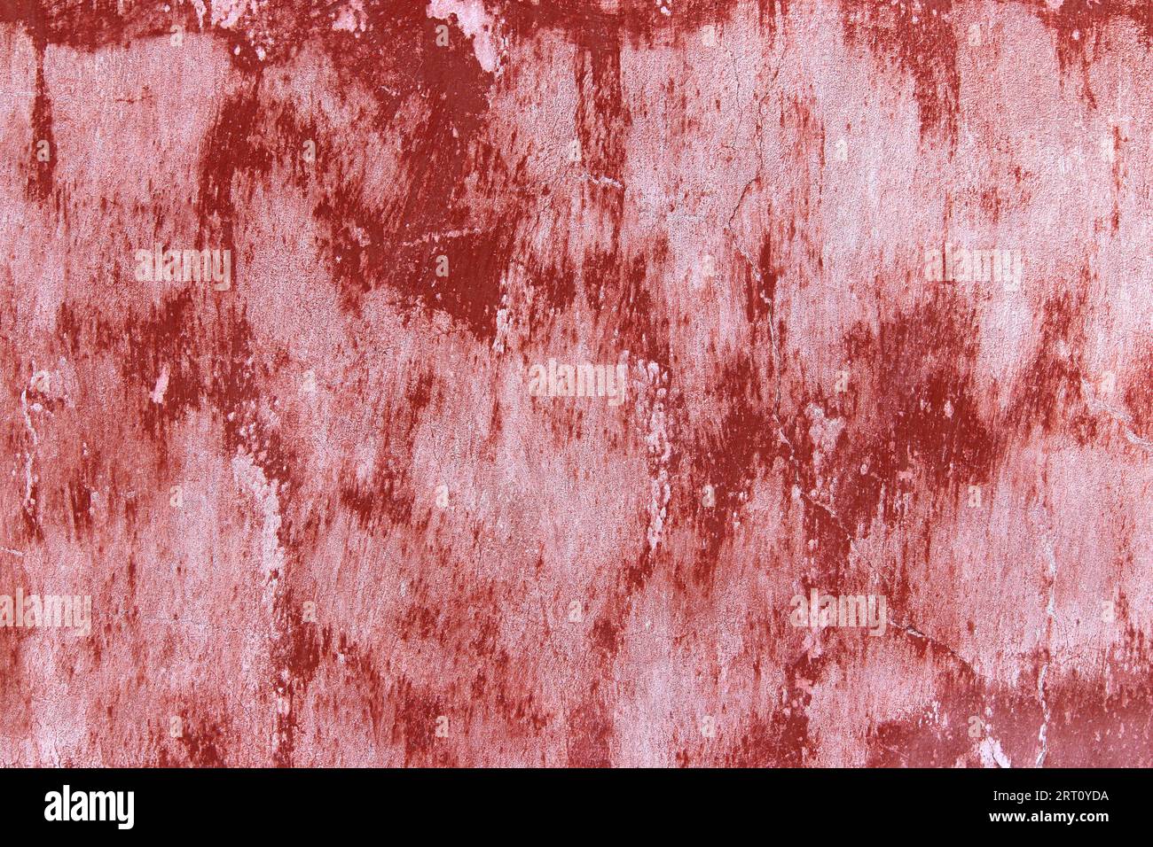 Rote Farbe verschmiert und an der Wand gemalt, abstrakter Grunge-Hintergrund Stockfoto