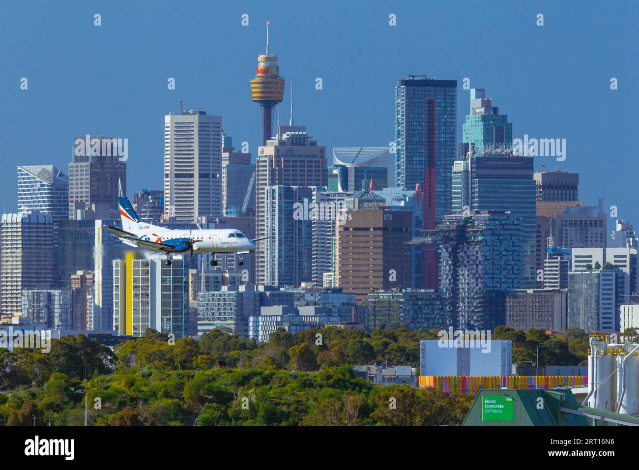 Die Skyline von Sydney, Australien, mit einem Rex Regional Express Flugzeug, das zum Flughafen Sydney abfährt. Stockfoto