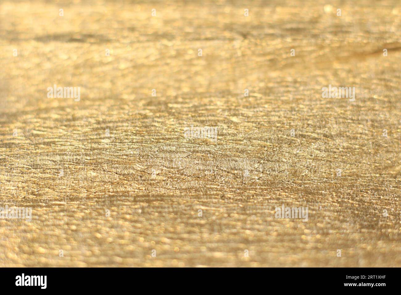 Ein goldener, faltiger Hintergrund mit Textur. Stockfoto