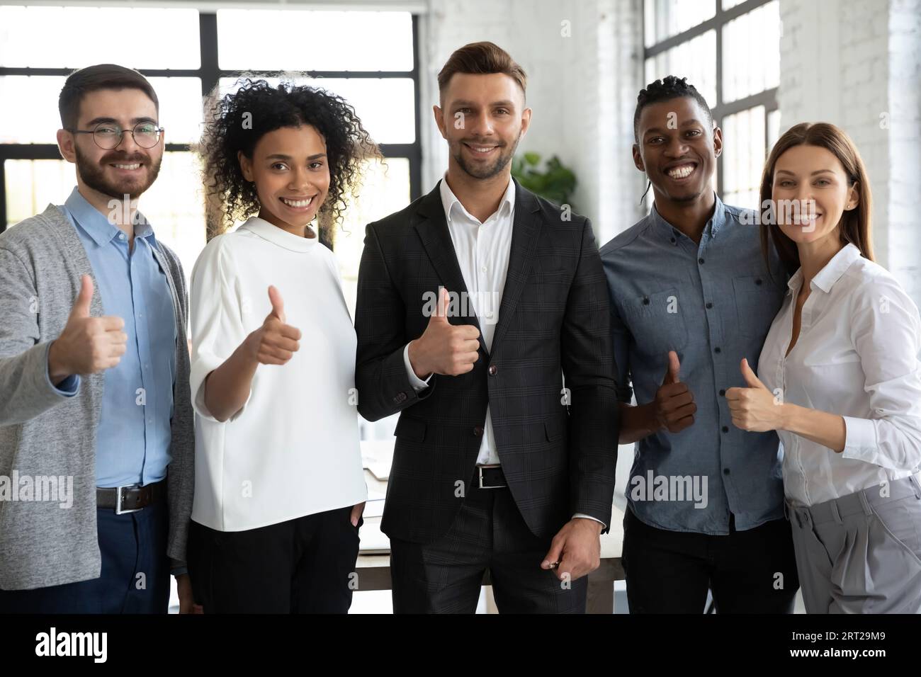 Porträt von lächelnden Kollegen aus verschiedenen ethnischen Gruppen, die guten Service empfehlen Stockfoto