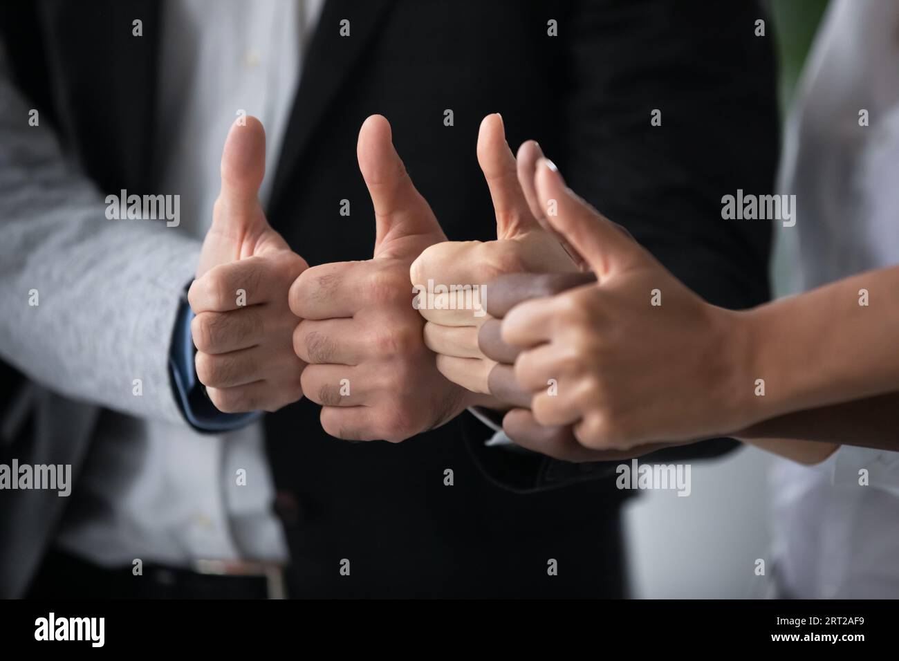 Nahaufnahme von Kollegen aus verschiedenen ethnischen Gruppen mit Daumen nach oben Stockfoto