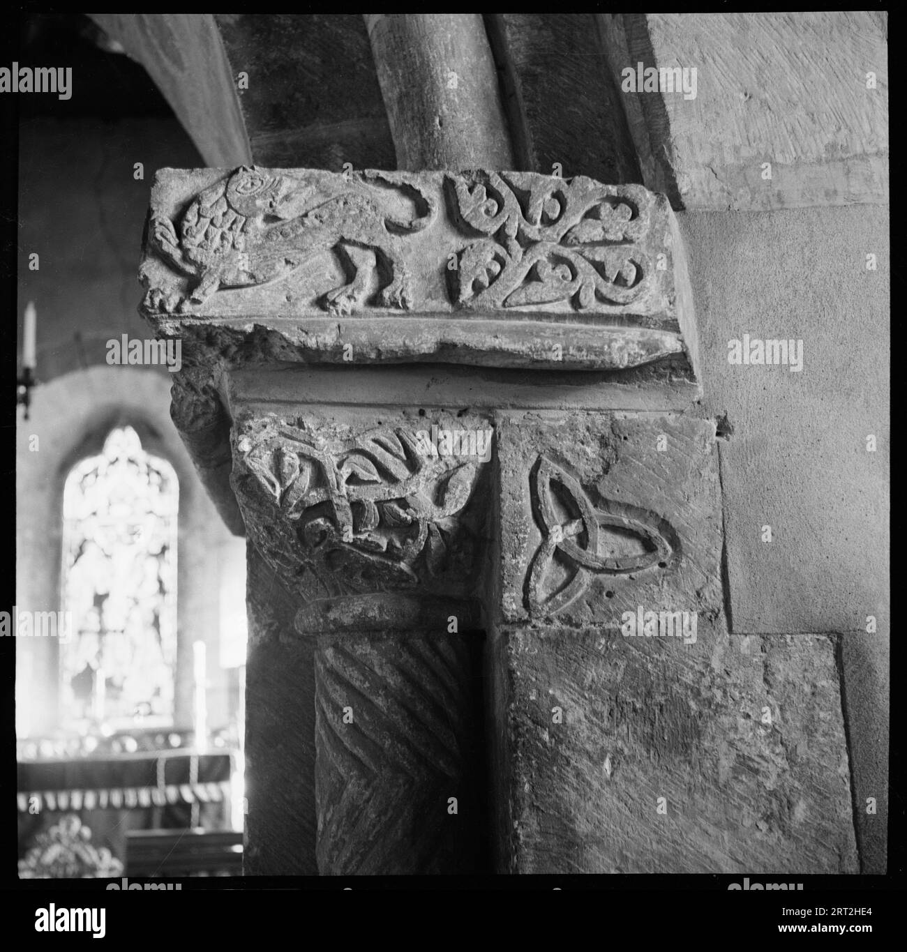 St Nicholas Church, Earls Croome, Malvern Hills, Worcestershire, 1938. Ein Detail mit aufwändigen romanischen Schnitzereien an der Südhauptstadt des Chorbogens der St. Nikolaus-Kirche, die Blumenmuster und einen Löwen mit Blick nach hinten zeigen. Stockfoto