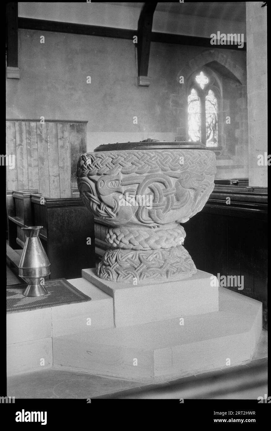 St. Cassian's Church, Chaddesley Corbett, Wyre Forest, Worcestershire, 1930-1940. Die normannische Schriftart in der St. Cassians Church, dekorativ mit Drachen und verflochtenen Bändern geschnitzt. Stockfoto