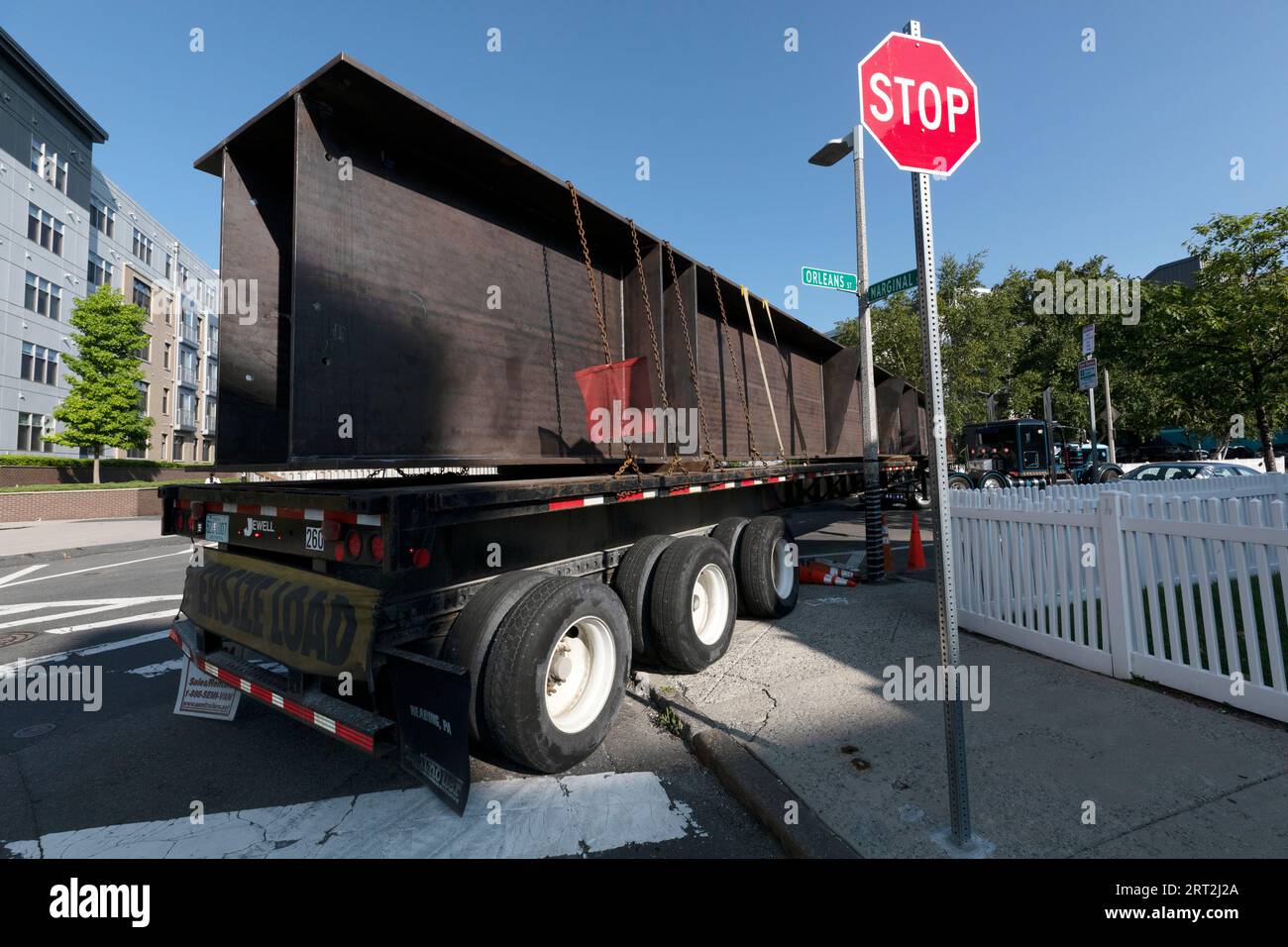 Großer Lkw mit Stahlbalken, der auf einer Wohnstraße in Boston, Massachusetts, abbiegt Stockfoto
