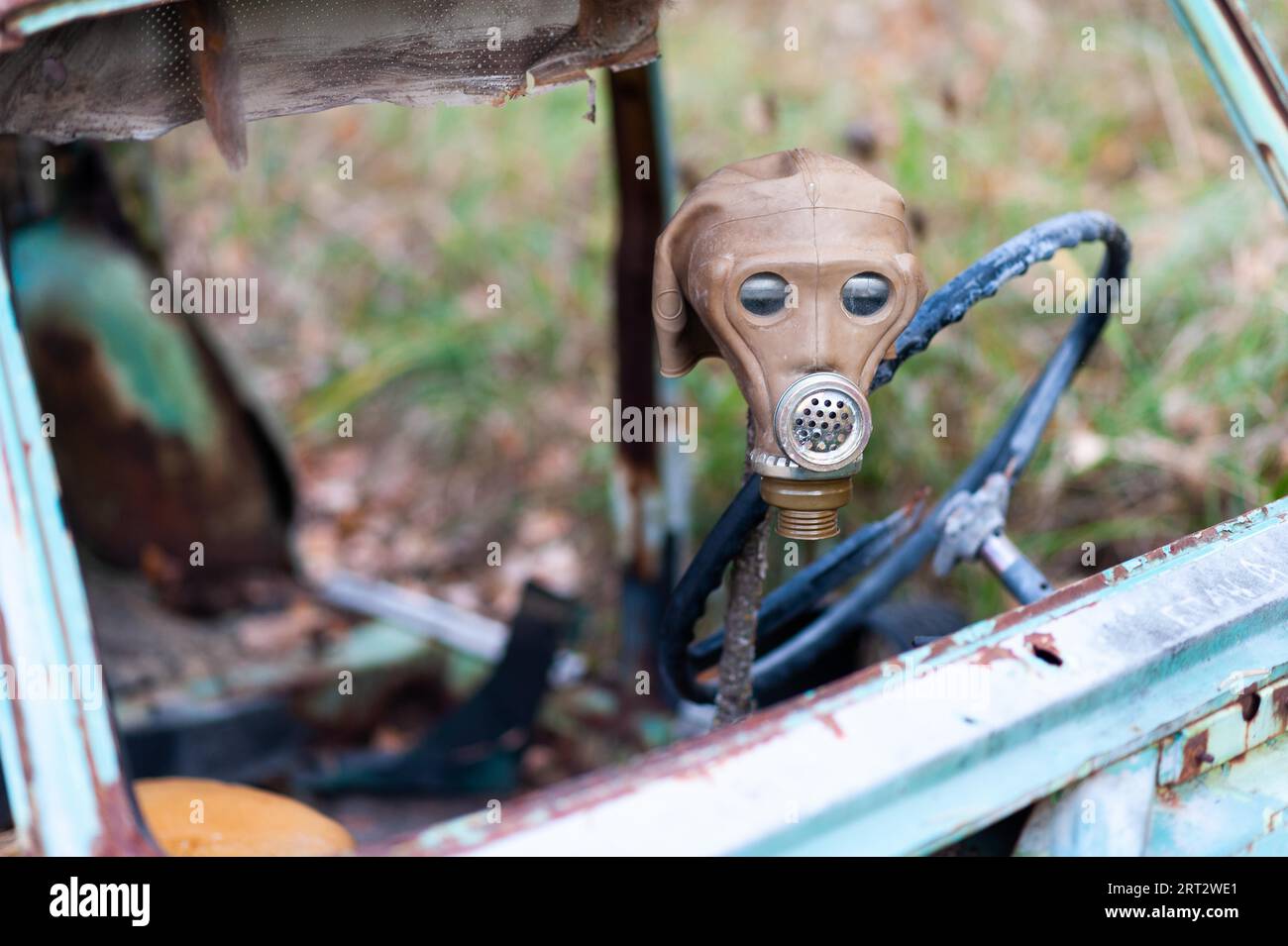 Alte gasmaske aus der sowjetunion drapierte am Lenkrad eines zerbrochenen Autos Stockfoto
