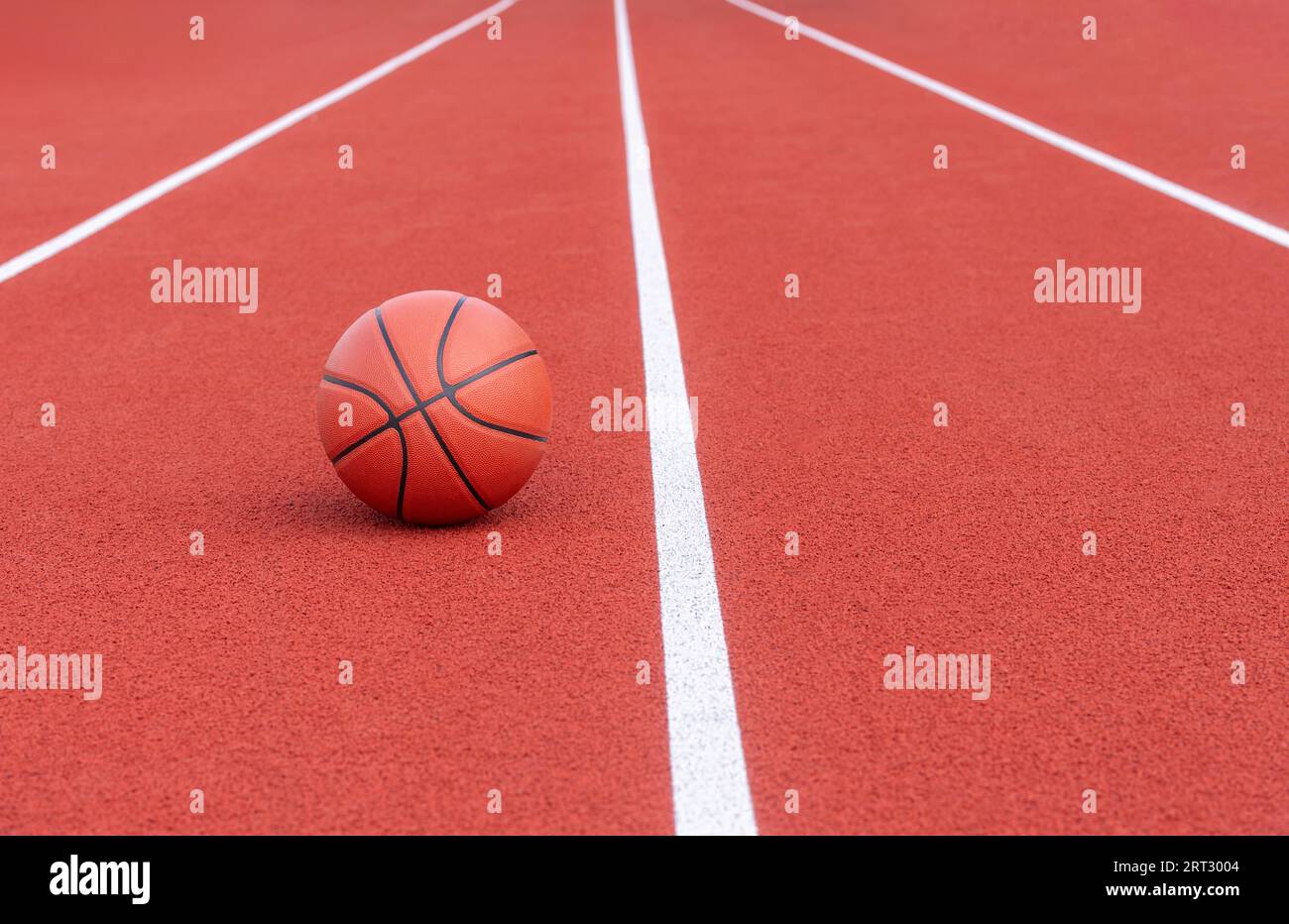 Neuer orangener Basketball auf orangenem Sportplatz des Gymnasiums. Horizontales Sportmotiv-Poster, Grußkarten, Kopfzeilen, Website und App Stockfoto