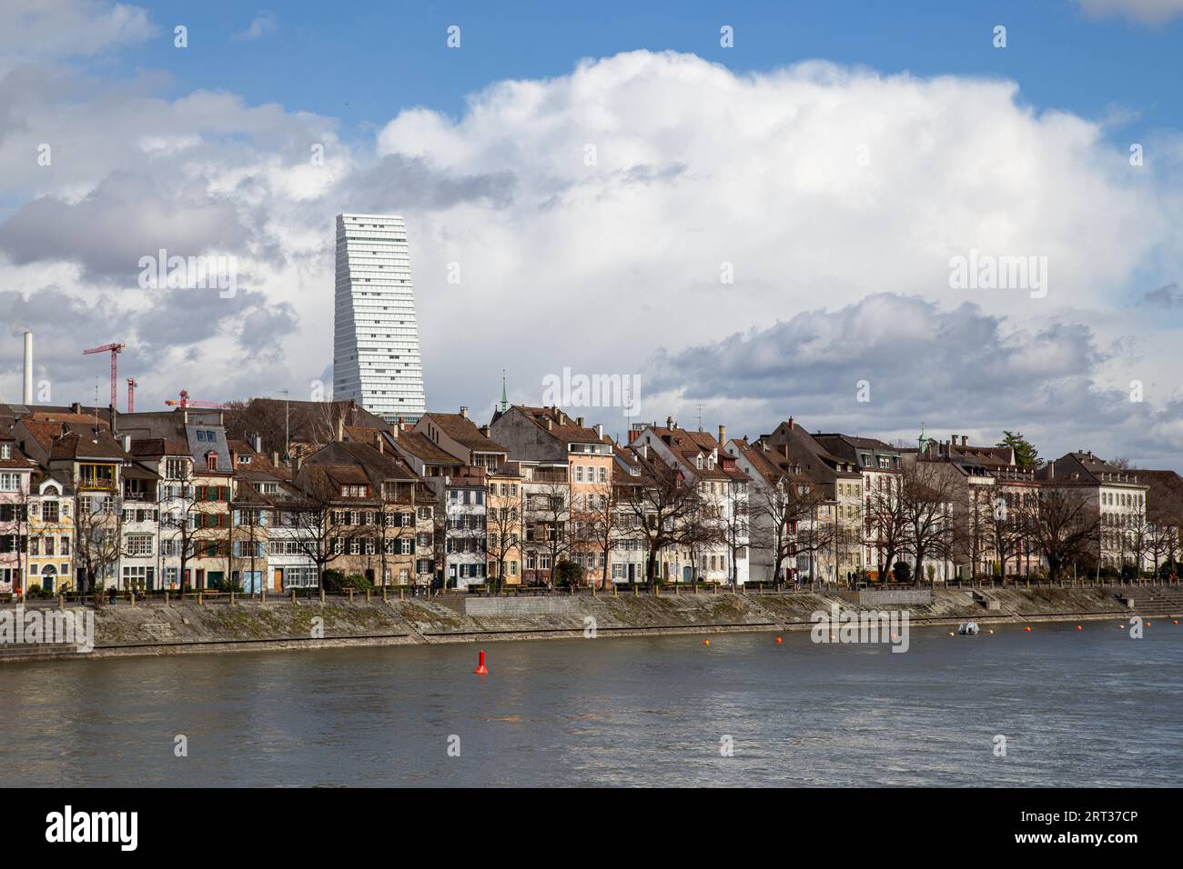 Basel, Schweiz, 11. März 2019: Rheinufer mit historischen Gebäuden und Roche-Turm im Hintergrund Stockfoto