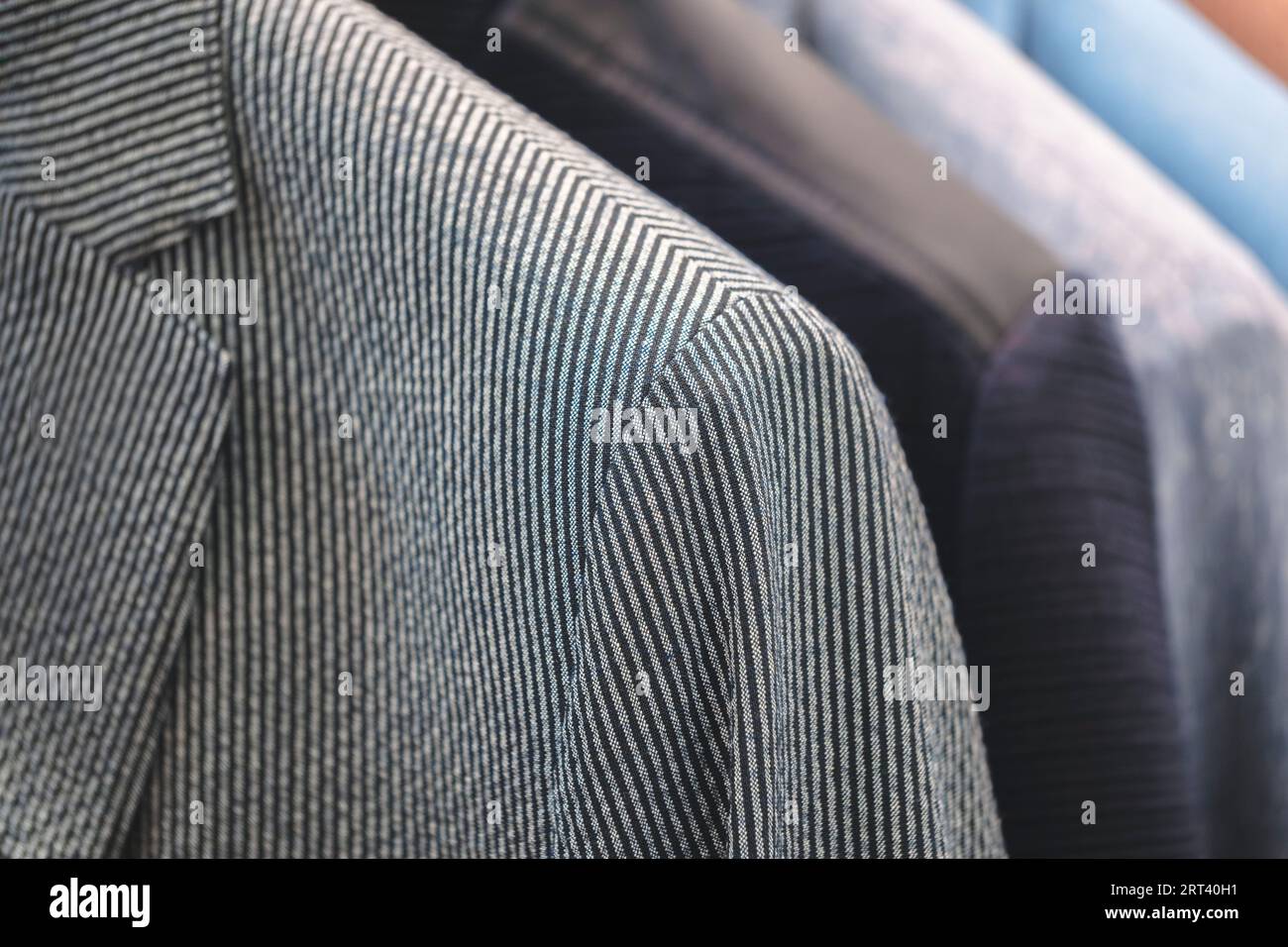 Regale mit verschiedenen Herrenanzügen in einer Boutique für Herrenbekleidung. Stockfoto