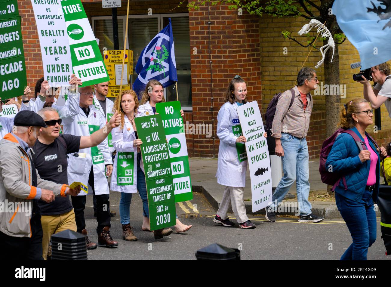 LONDON - 22. April 2023: Ärzte marschieren in London mit Protestplakaten bei der Veranstaltung „Extinction Rebellion“, die sich für Klimaschutz einsetzen. Stockfoto