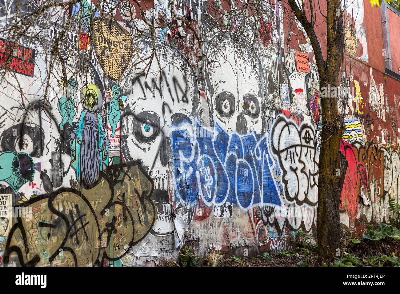 Alte Grunge-Wandkunst, ruiniert von Graffiti, an der Seite eines Gebäudes im Alberta Arts District in Portland, Oregon Stockfoto