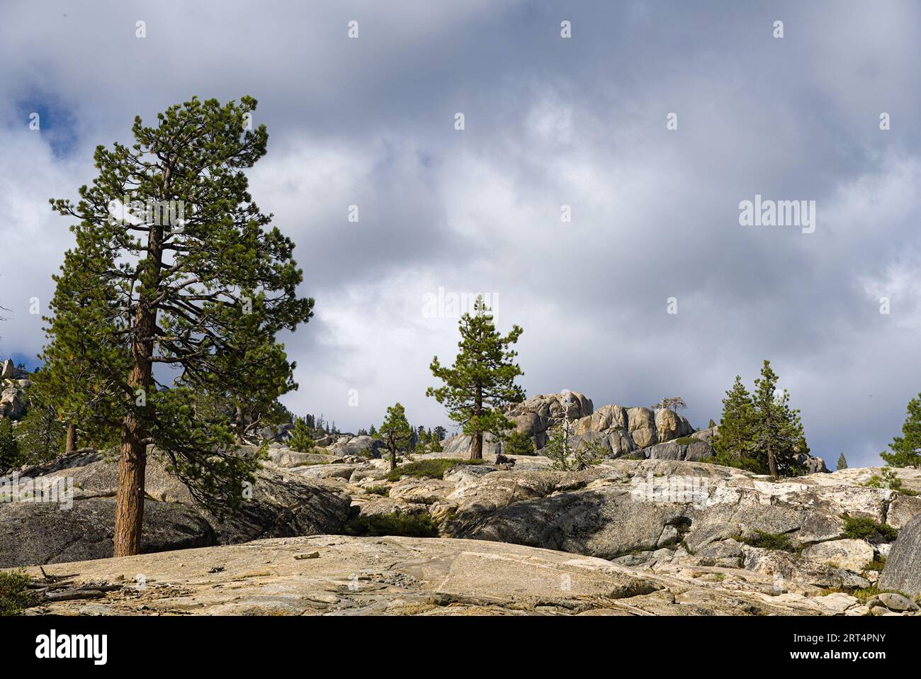 Berggipfel aus Granit unter bewölktem Himmel. Stockfoto
