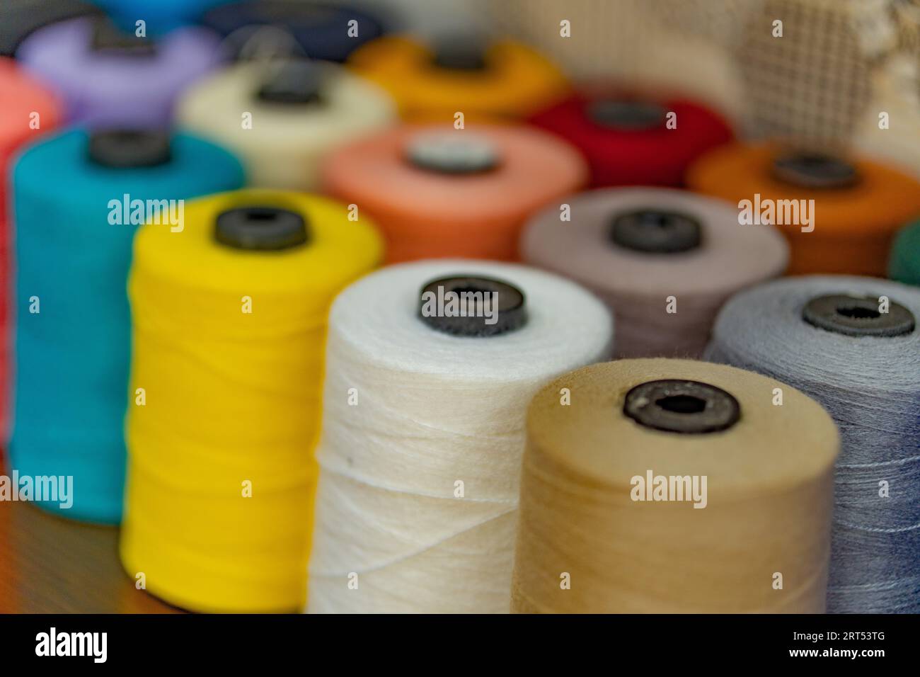 Buntes Garn auf Spule, Schlauch, Baumwolle, Wolle, Leinenfaden. Bunte Fadenspule Hintergrund, Nahaufnahme. Mehrfarbige Fäden zum Nähen und Nähen Stockfoto
