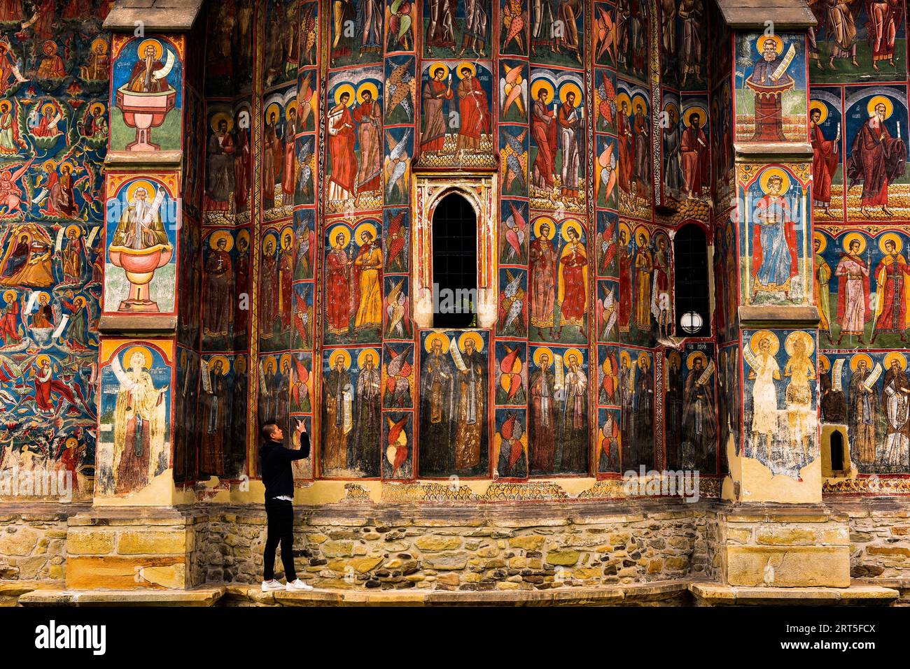 Tripod Selfie vor den gemalten Fresken des Klosters Moldovița in der abgelegenen Region der Bukowina im Nordosten Rumäniens, einer UNSECO WH-Stätte Stockfoto
