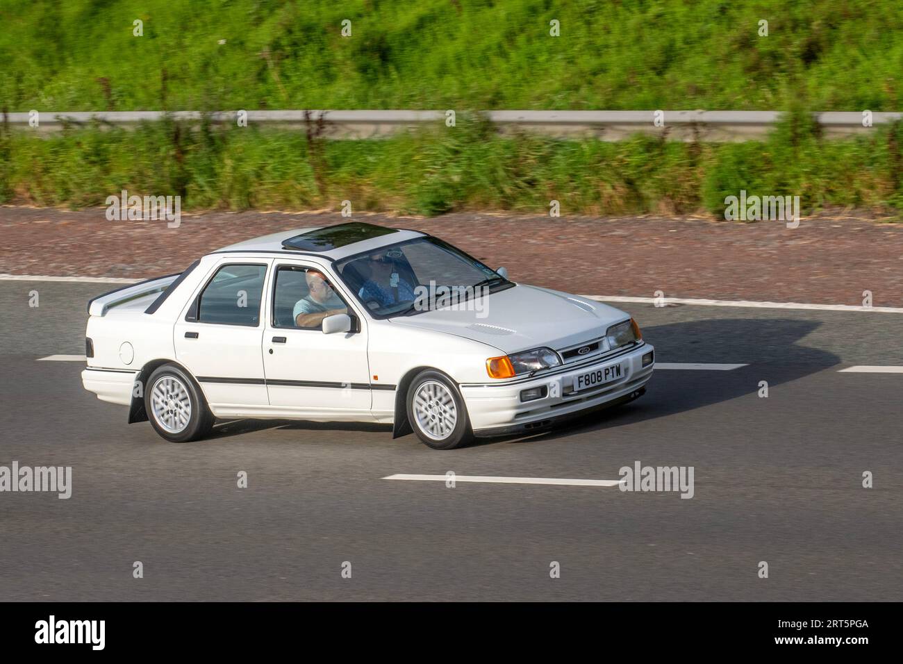 1989 80er Jahre Ford Sierra RS Cosworth White Car Saloon Benzin 1993 ccm; Fahrt mit Geschwindigkeit auf der Autobahn M6 in Greater Manchester, Großbritannien Stockfoto