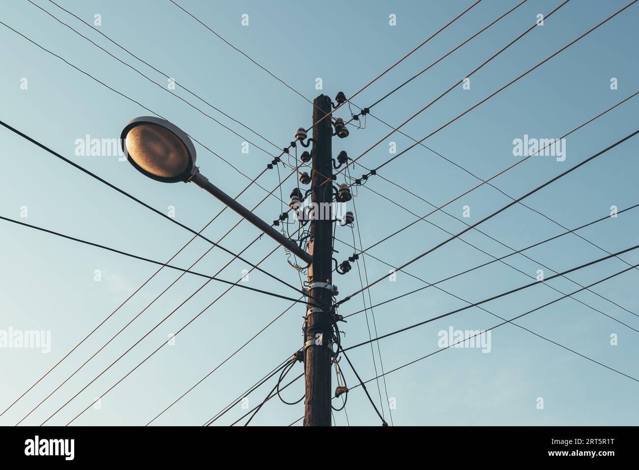 Straßenlaterne mit Strommast und Stromkabeln, Blick aus einem niedrigen Winkel Stockfoto