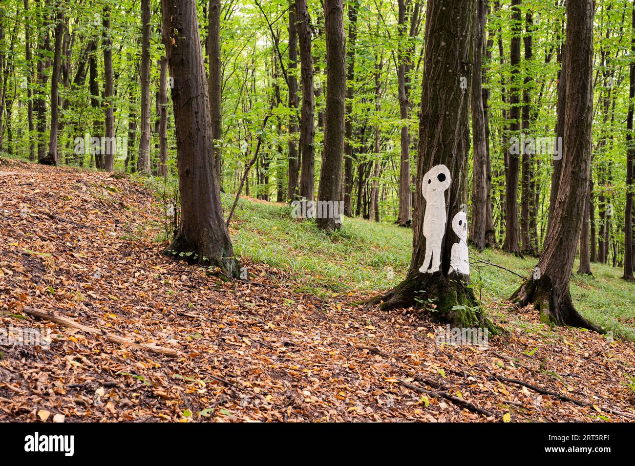 Halloween-Paar Silhuetten, Geister oder Außerirdische, die auf dem Baum im Wald abgebildet sind. Landschaftlich, mystisch, Postkartenansicht, Hintergrundbild Stockfoto
