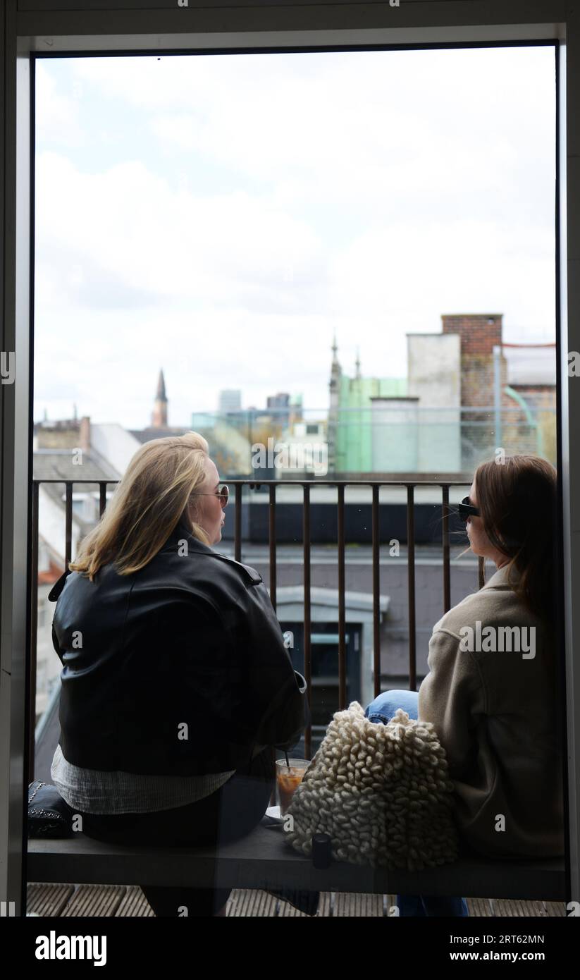 Einheimische und Touristen genießen den Blick auf die Stadt vom Balkon des ursprünglichen Kaffeehauses in Kopenhagen, Dänemark. Stockfoto