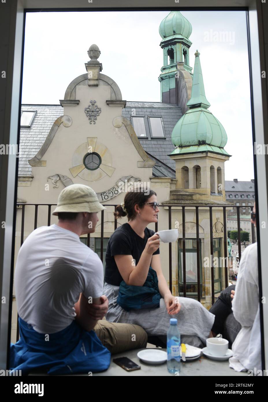 Einheimische und Touristen genießen den Blick auf die Stadt vom Balkon des ursprünglichen Kaffeehauses in Kopenhagen, Dänemark. Stockfoto
