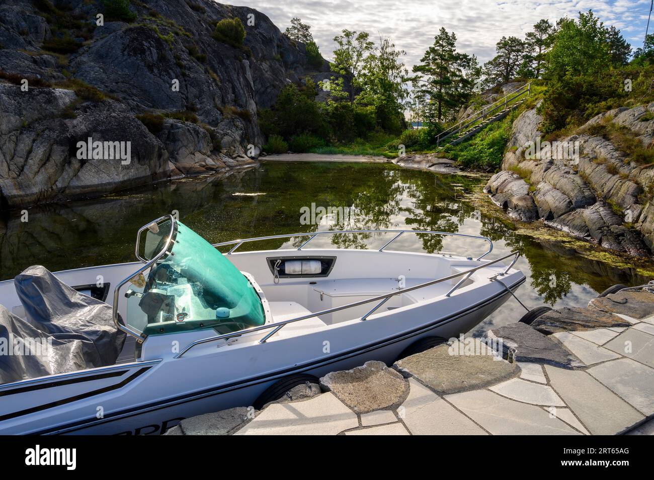 Ein Nordkapp-Schnellboot legte an einem privaten Steg im frühen Morgenlicht auf einer Insel im Kragero-Archipel, Telemark, Norwegen, an. Stockfoto