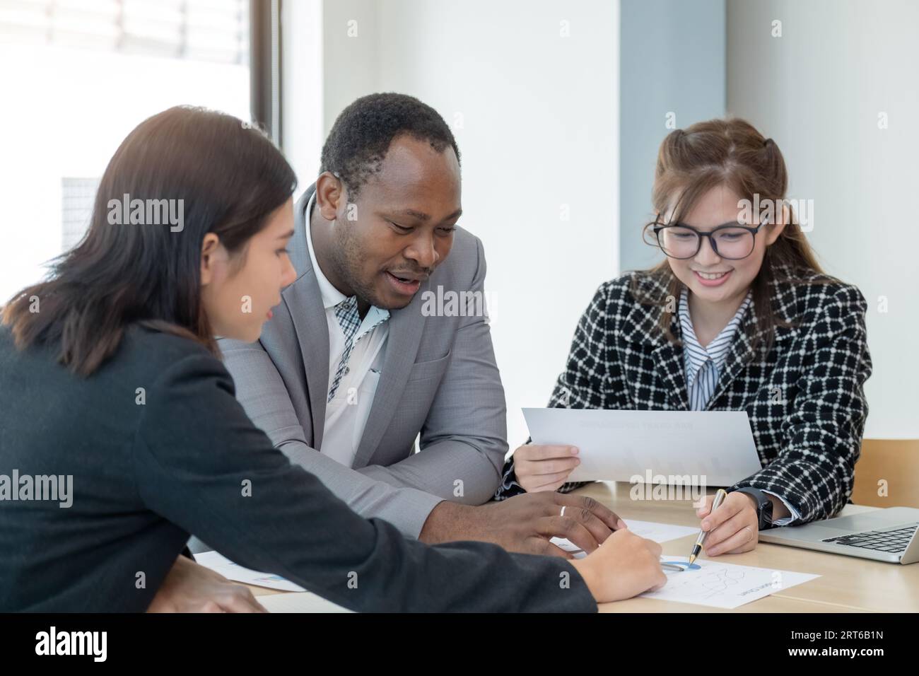 Multiethnische Kollegen sammeln sich in Vorstandssitzungen, um gemeinsam Finanzdokumente von Analysten und Unternehmen zu erstellen. Verschiedene Mitarbeiter bei Team-Office-Meetings Stockfoto