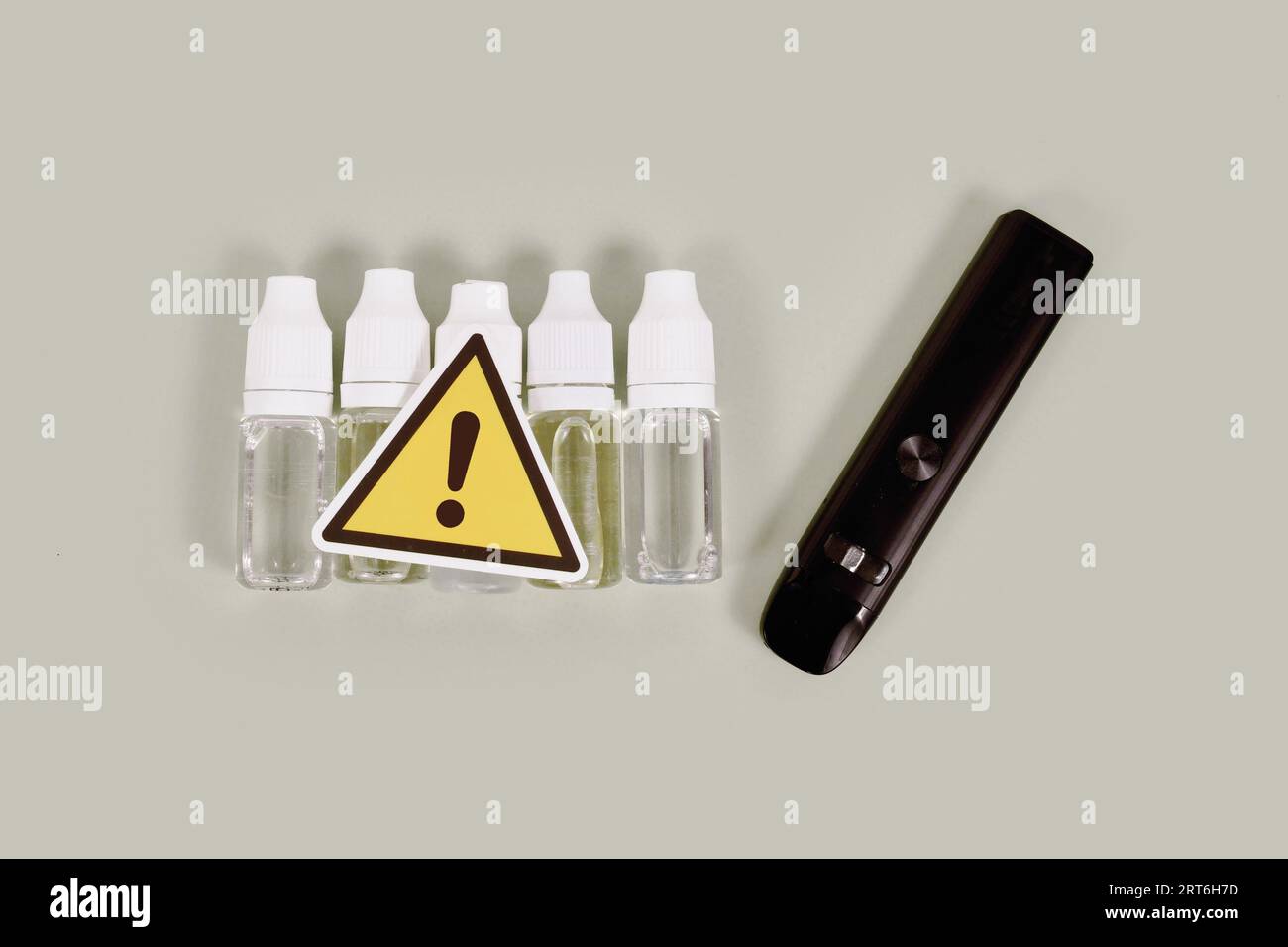 Flaschen mit flüssigen Lösungen und elektronische Zigaretten mit Warnschild Stockfoto